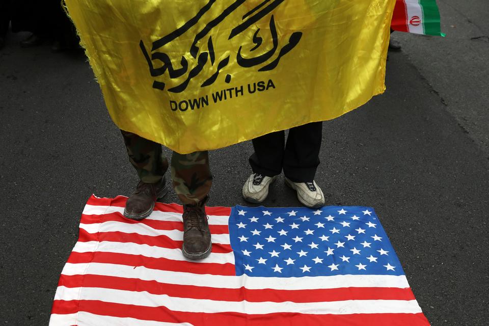 متظاهرون إيرانيون أمام مقر السفارة الأمريكية سابفا ويحملون يافطة 