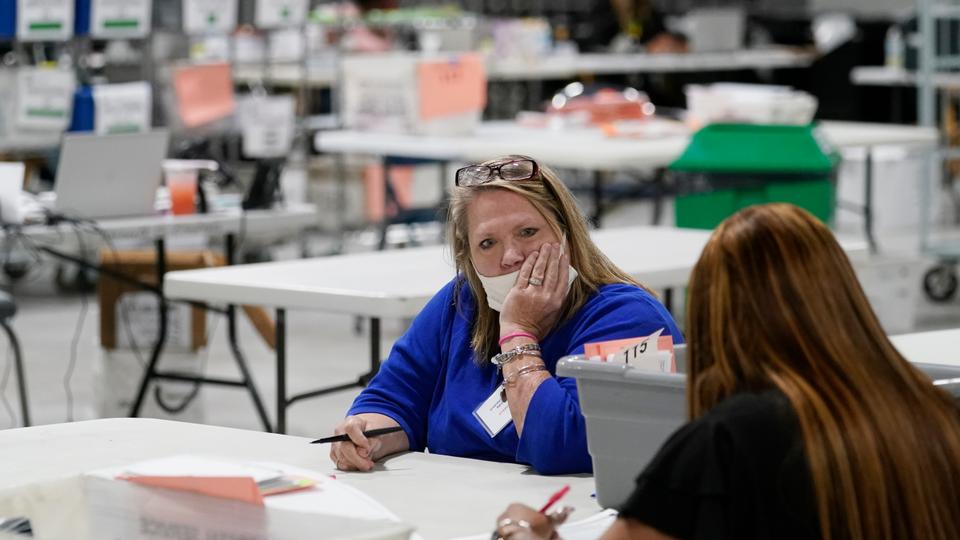 Poll workers await ballots at the Gwinnett County Voter Registration and Elections Headquarters, Friday, Nov. 6, 2020, in Lawrenceville, near Atlanta. (AP Photo/John Bazemore)